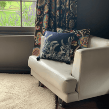 Load image into Gallery viewer, sage grevillea printed on indigo square linen designer cushion with tassels on white sheets on white leather lounge chair with salvias visible in the window