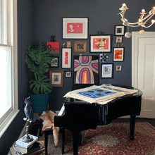 Load image into Gallery viewer, Living room with Indigenous Australian Art on a baby grand piano and monstera
