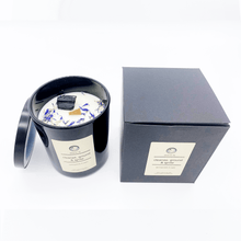 Load image into Gallery viewer, A picture of a large white candle sprinkled with flower petals and a crystal imbedded in it next to the box it comes in.
