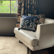 Load image into Gallery viewer, sage grevillea printed on indigo square linen designer cushion with tassels on white sheets on white leather lounge chair with salvias  visible in the window
