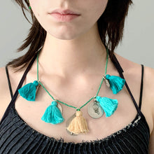 Load image into Gallery viewer, Ethically sourced Old Fashioned Online green beaded necklace with Turquoise tassels and five silver amulet charms on girl wearing blue denim
