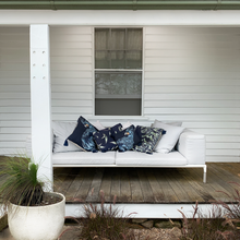 Load image into Gallery viewer, printed Australiana blue square linen designer cushions with tassels on a lounge on the veranda of a country estate
