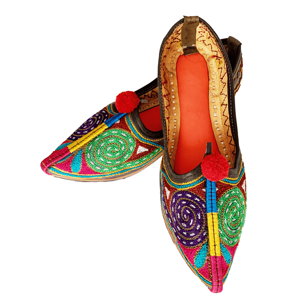 Ethically sourced bohemian Old Fashioned Online flats with purple, green and gold spiral path embroidery, red pompoms and cushioned footbed
