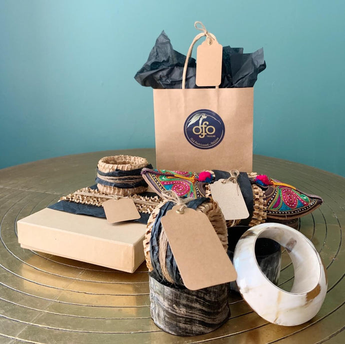 A picture of Old Fashioned Online gifts wrapped in brown paper on a brass table top 