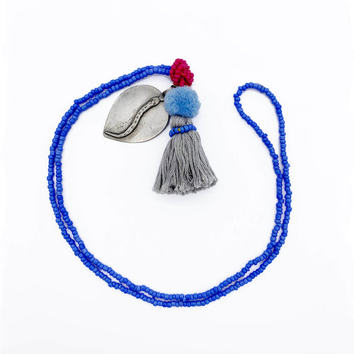 Colorful Old Fashioned Online beads with tassel, pompom and silver amulet charm necklace in pink and blue flat lay
